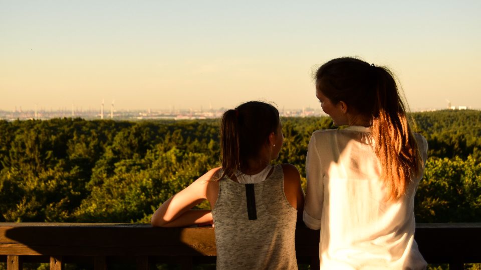 Zwei Menschen genießen die Aussicht vom Elbblickturm im Wildpark Schwarze Berge in Hamburgs Süden