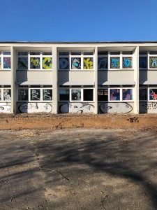 Gebäudewand der Stadtteilschule Stellingen, ein verlassener Ort in Hamburg, mit Graffiti und fehlenden Fenstern