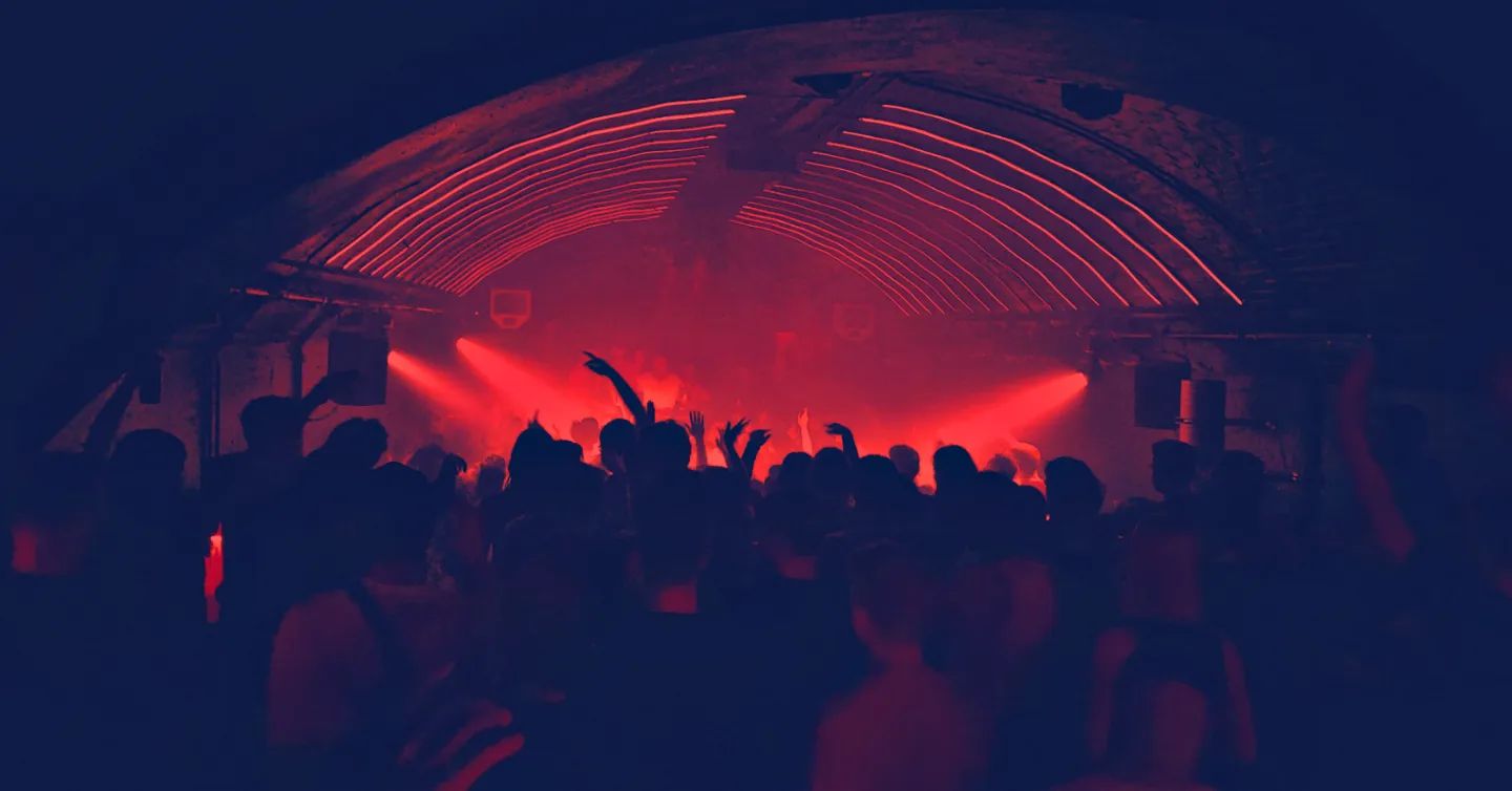 unkenntliche Menschenmenge tanzt in einem Techno Club in Hamburg in rotem Licht