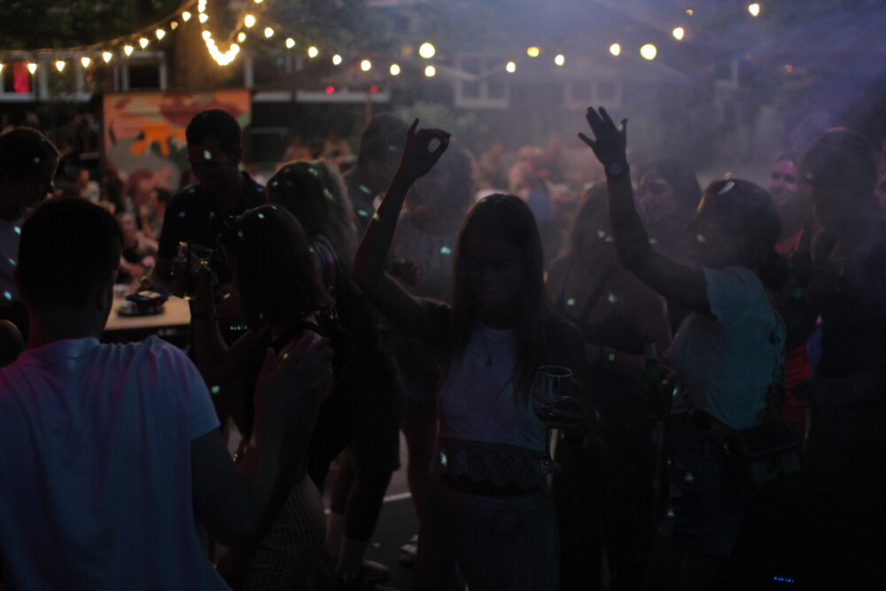 unkenntliche Menschen tanzen unter Lichterketten in der Nacht in einer Open-Air-Location in Hamburg