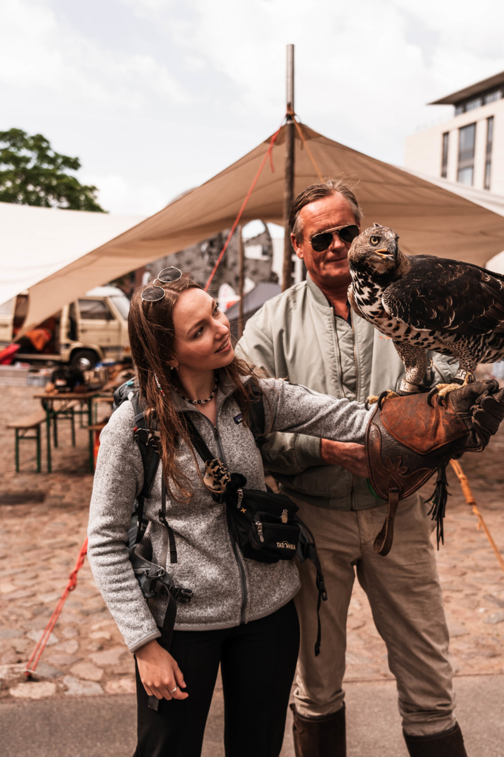 Besucher mit Adler auf dem Arm