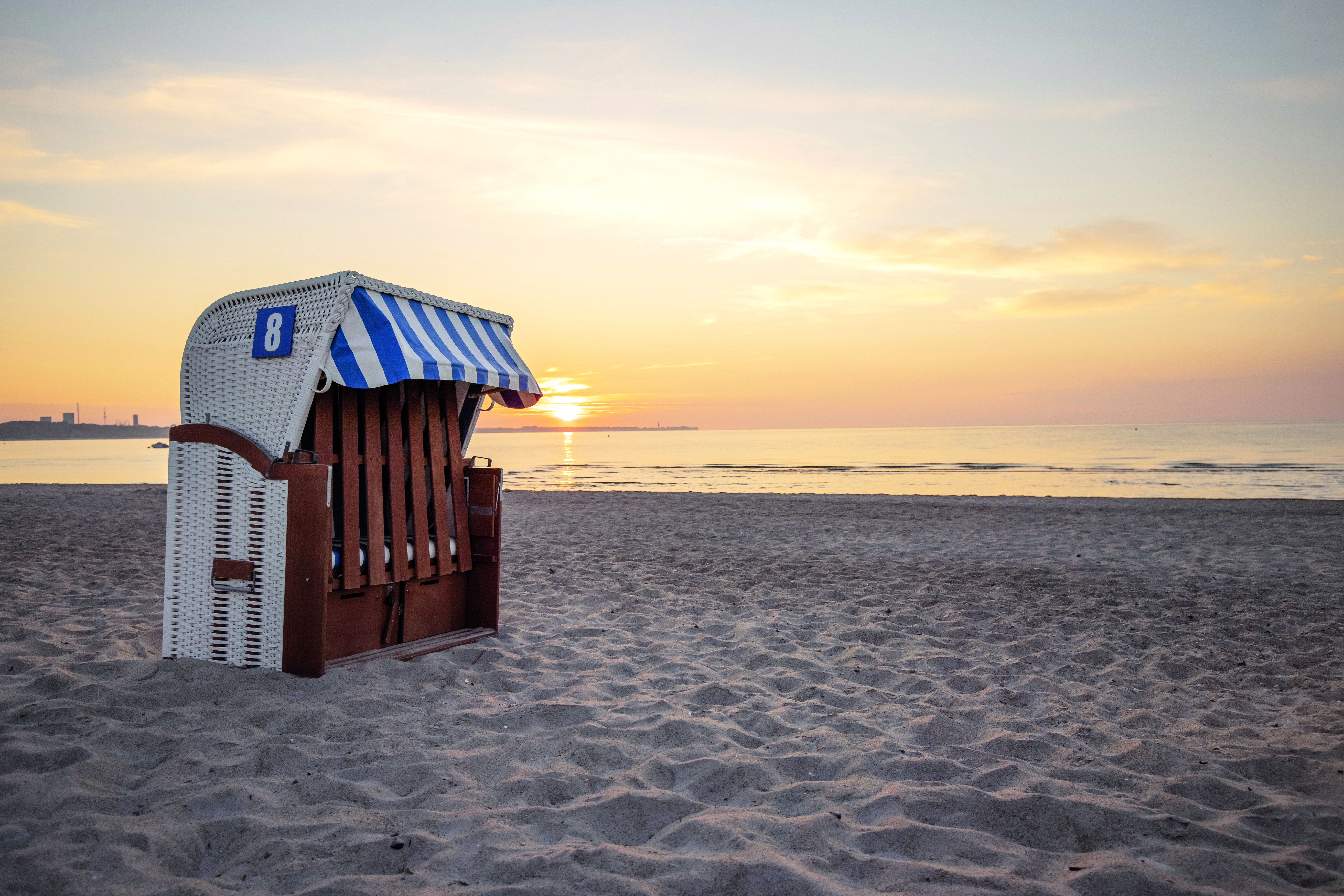 Ein einsamer Strandkorb am Strand in Scharbeutz an der Lübecker Bucht bei Sonnenaufgang