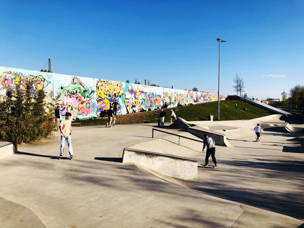 Leute fahren auf ihren Skateboards durch den Skatepark im Wilhelmsburger Inselpark.