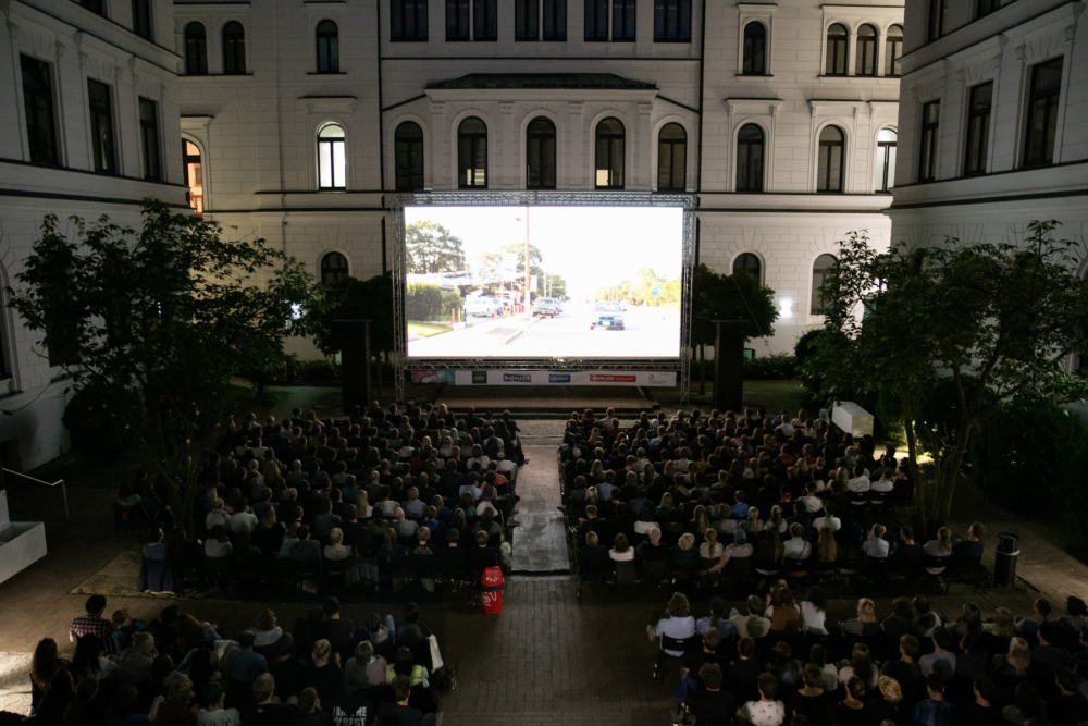 Bestuhltes Publikum vor Open-Air-Kinoleinwand im Innenhof des denkmalgeschützen Altonaer Rathaus