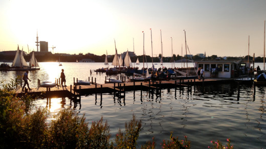 Steg mit Bootsverleih auf der Alster bei Sonnenuntergang