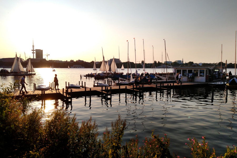 Steg mit Bootsverleih auf der Alster bei Sonnenuntergang