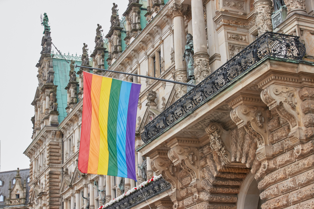 Eine Regenbogenflagge ist an der Frontseite des Hamburger Rathaus gehisst