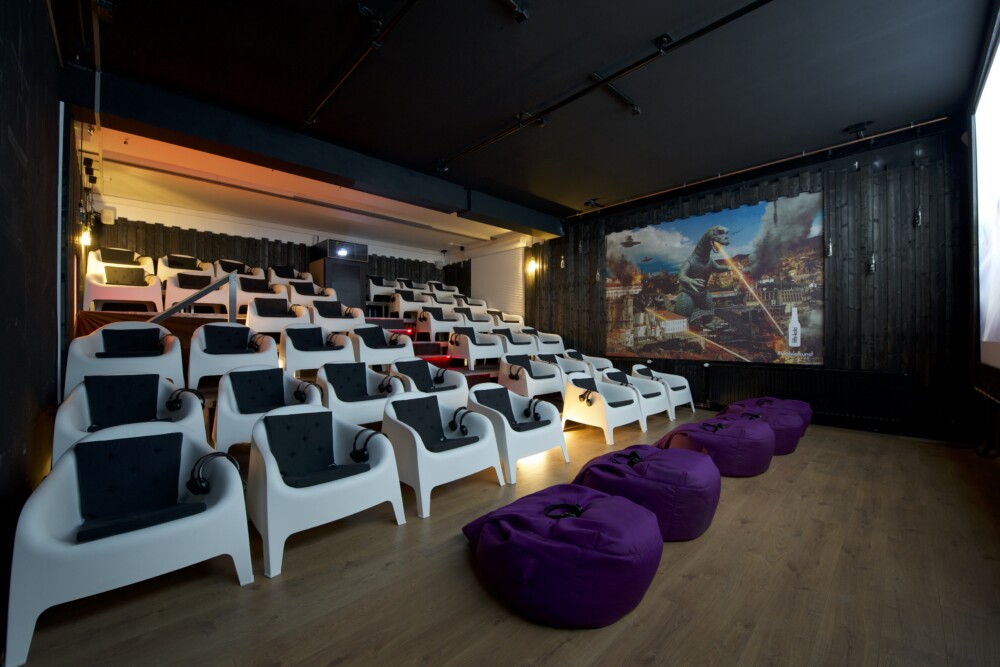weiße Loungesessel und lila Sitzsäcke im kleinen Kinosaal im Schanzenkino73