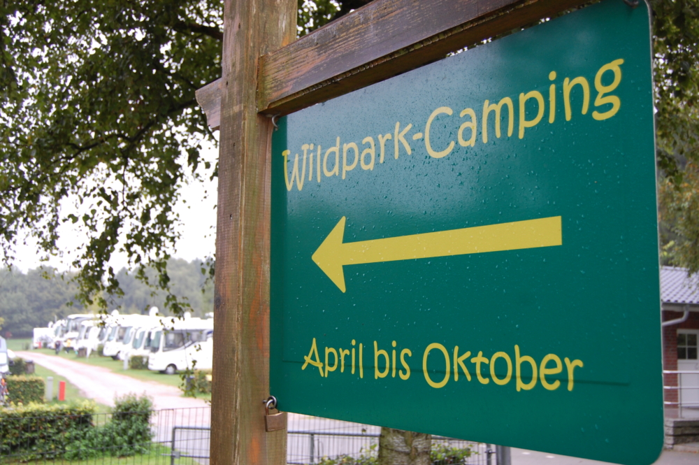 Auskunftsschild mit der Aufschrift Wildpark Camping von April bis Oktober