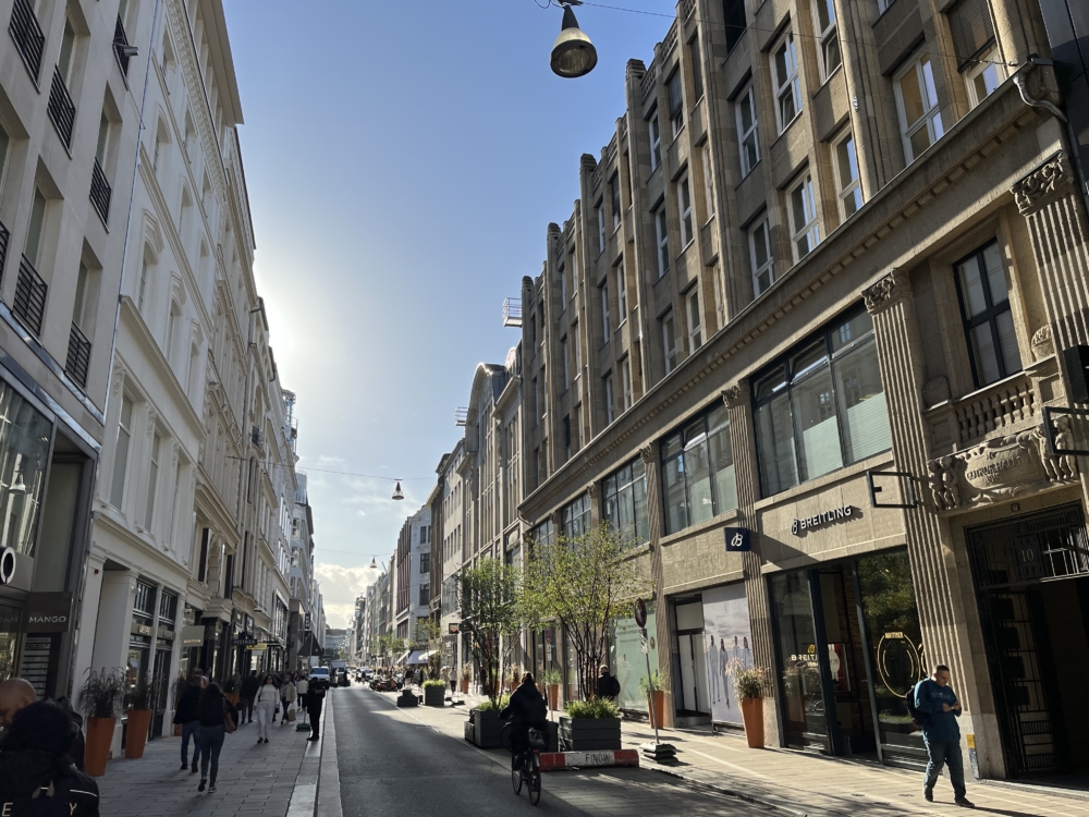 Breite Bürgersteiger auf denen Menschen gehen, Lampen zieren den Neuen Wall, die Luxus Einkaufsstraße in Hamburg 