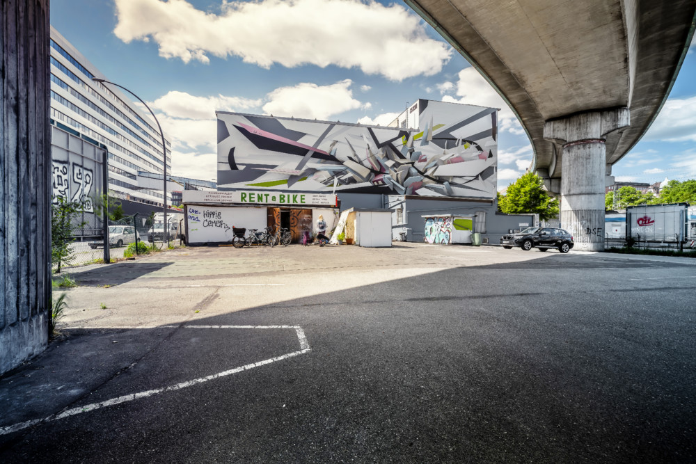Die Seitenfassade der OZM HAMMERBROOKLYN Galerie schmückt ein buntes Graffiti von Künstler DAIM