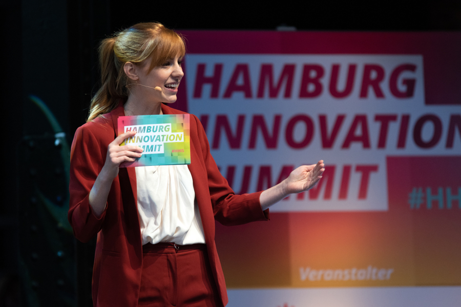 Eine Frau moderiert auf der Bühne