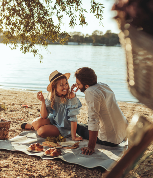 Glückliches Pärchen beim Picknick am Wasser