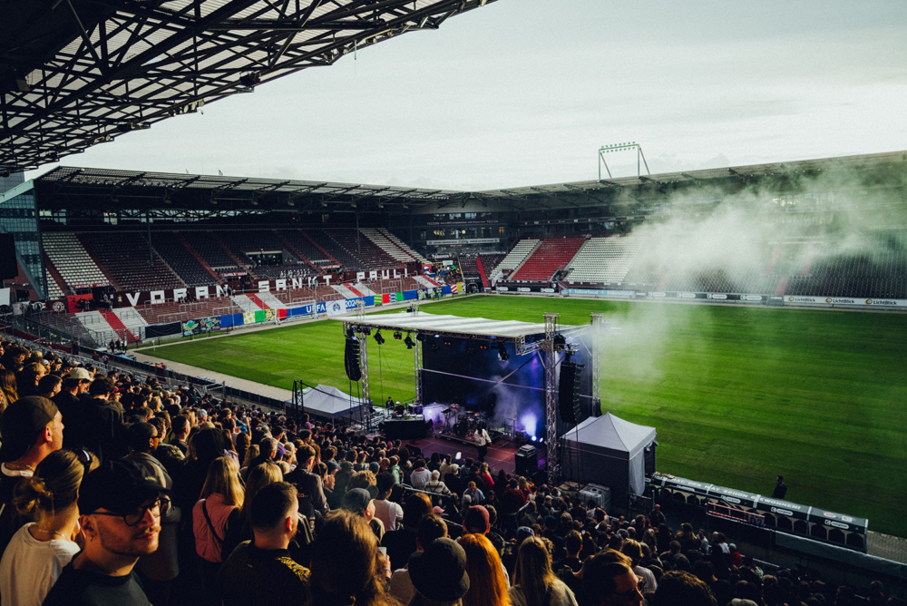 Die Main Stage des Festivals, welche am Rande des Rasenplatzes des Millerntor-Stadions angebracht ist. Gerade läuft ein Konzert und ein großes Publikum schaut auf die Bühne.