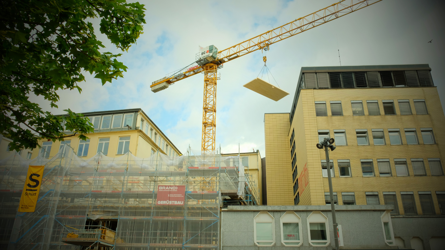 Holzplatten werden durch einen Kran auf das neue Amt gehoben