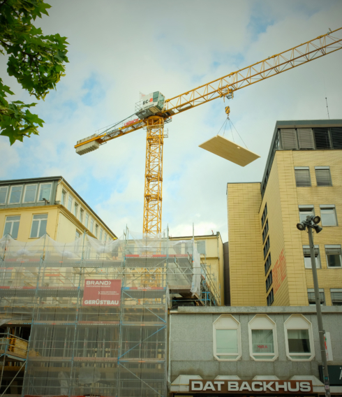 Holzplatten werden durch einen Kran auf das neue Amt gehoben