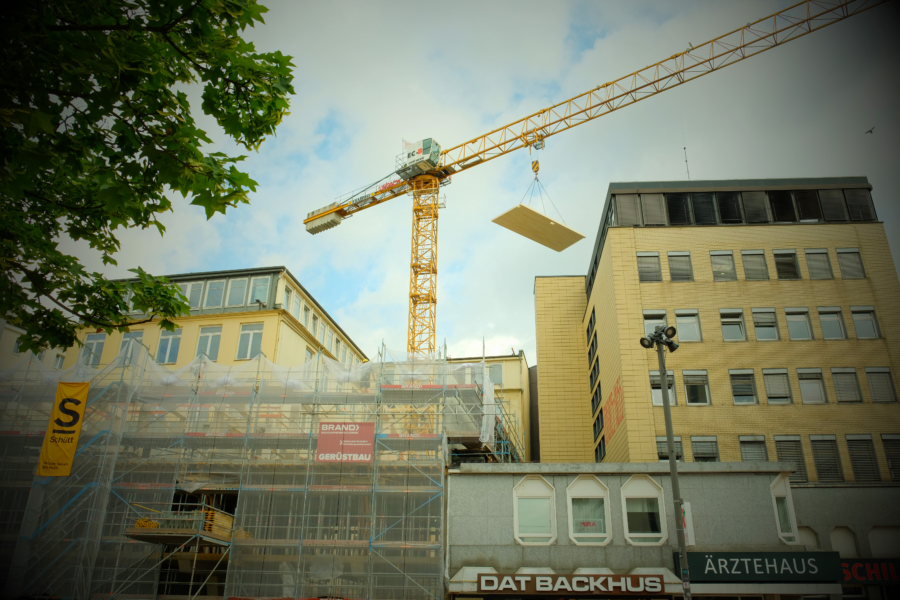 Holzplatten werden durch einen Kran auf das neue Amt gehoben