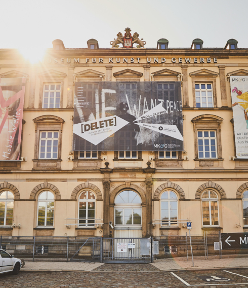 Das MK&G von Außen in der Frontalansicht. Ein großes Altbaugebäude in der Stadt