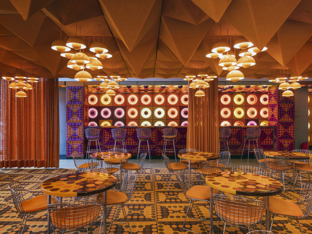 Zu sehen ist: Die ehemalige Kantine des SPIEGEL. Der Kantine ist in grellen orange, lila und braun tönen gehalten. 