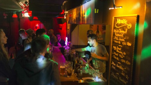 Barkeeper hinter der Bar und Menschen vor der Bar