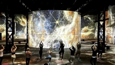 Personen die Yoga machen vor Universums-Projektionen