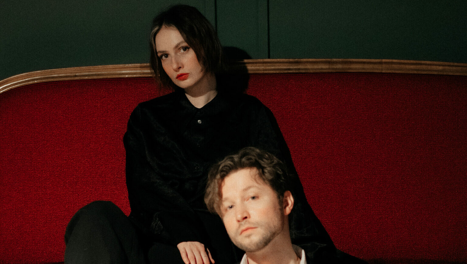 Bild von Nick & June: June sitzt auf einem Sofa, Nick davor