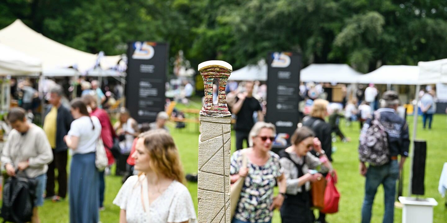 Die Christianswiese mit Menschen und Ständen mit Kunstwerken