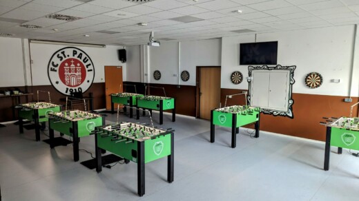 7 Kicker in einem Raum mit St. Pauli Logo an der Wand
