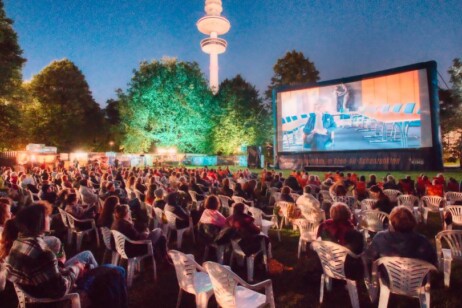 Menschenmenge vor einer großen Leinwand draußen