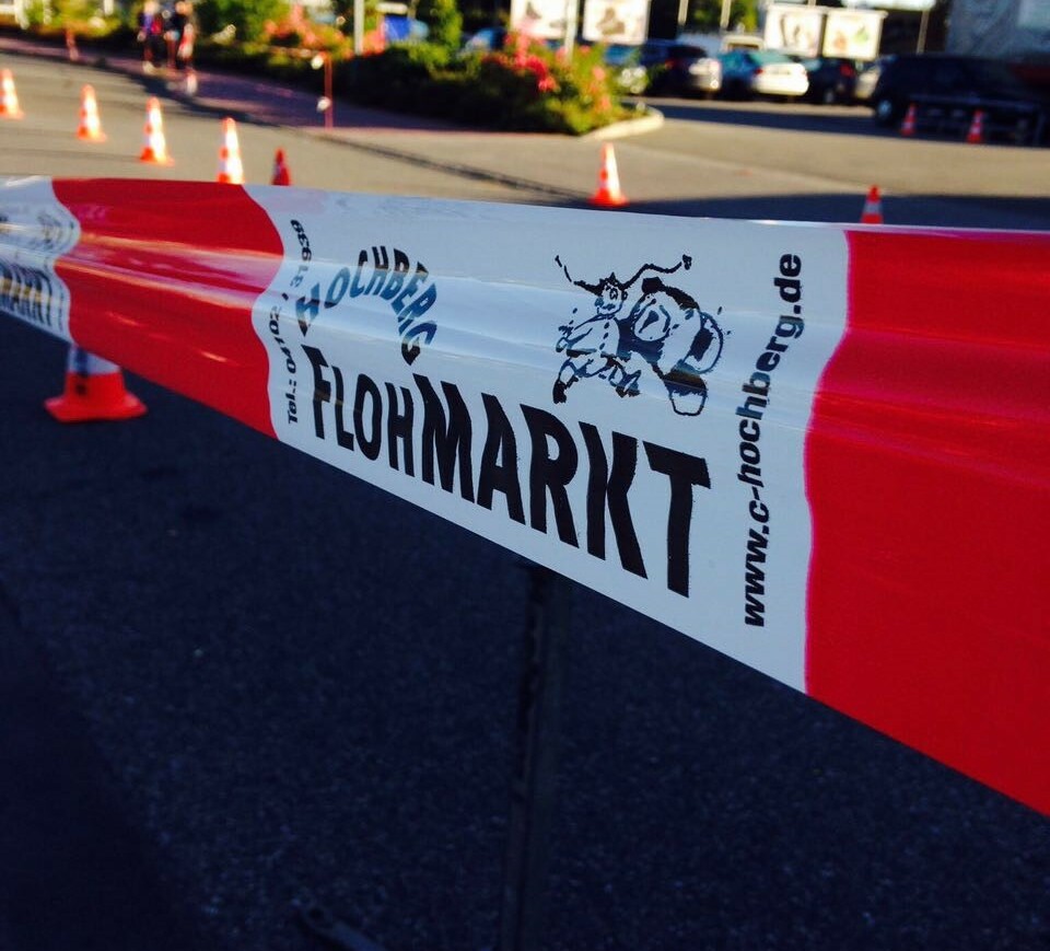 Eine Straße mit einem Absperrband mit der Aufschrift "Flohmarkt"