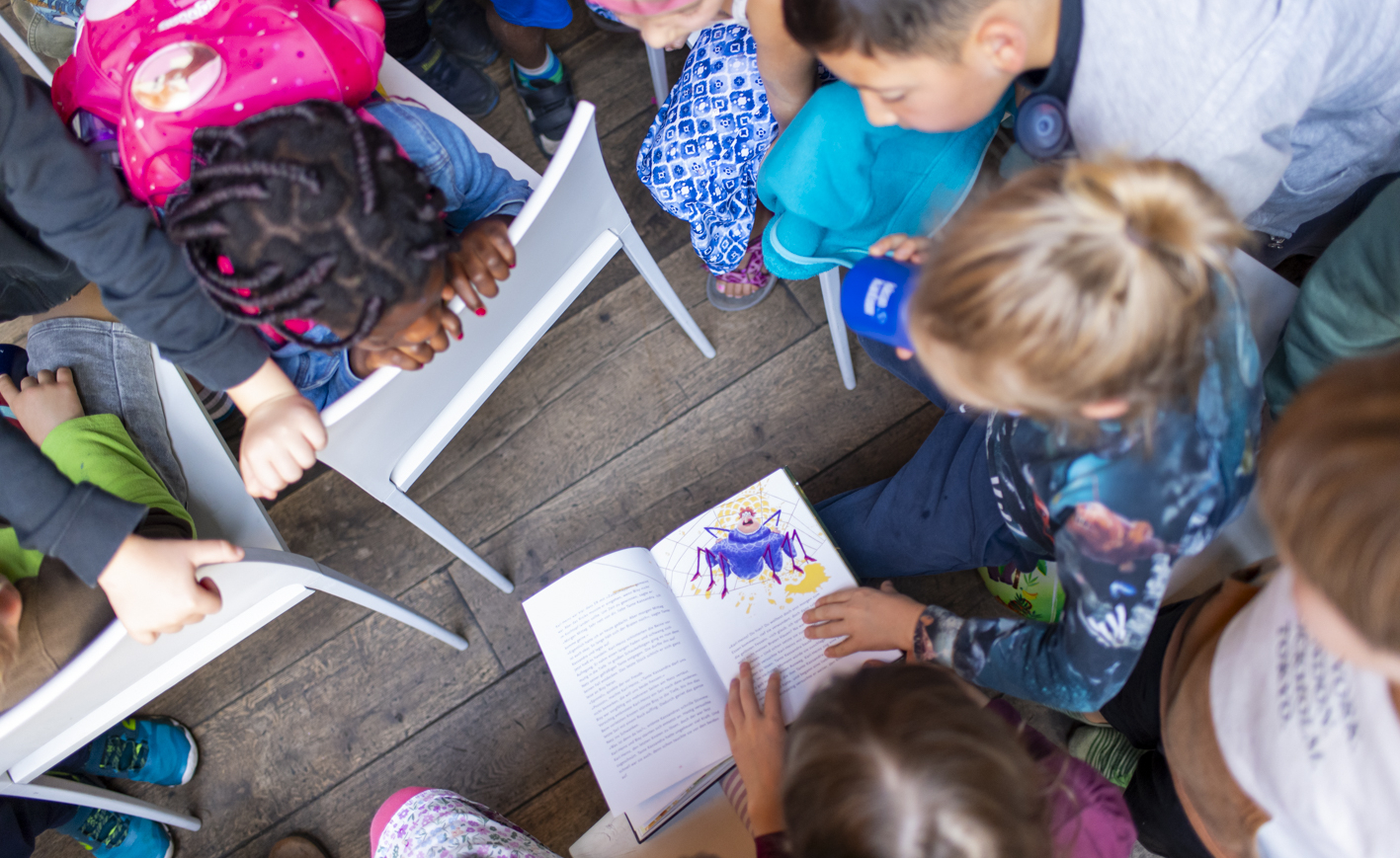 Kinder, die über ein Buch gebeugt sind