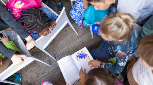 Kinder, die über ein Buch gebeugt sind