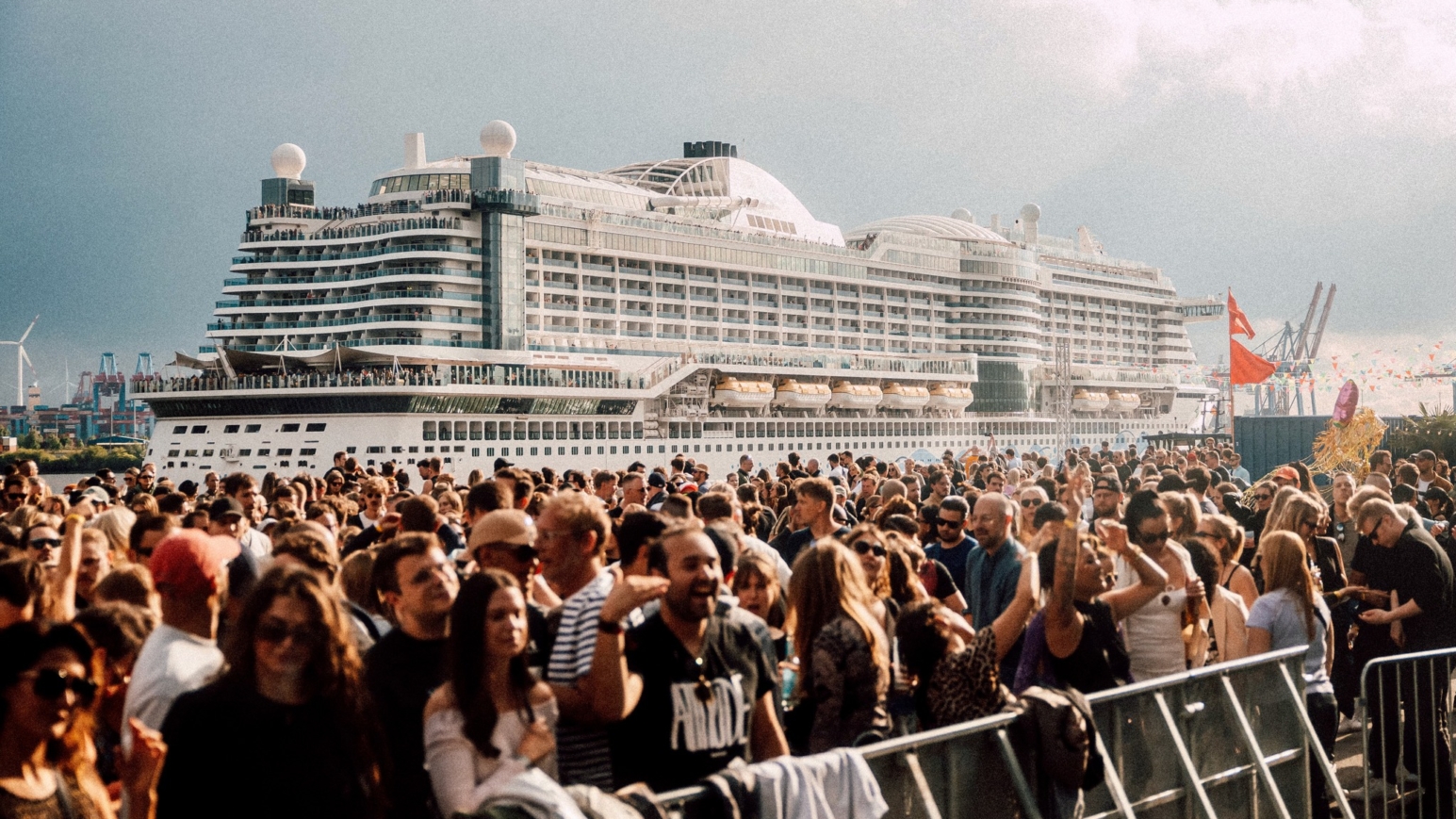 eine Menschenmenge und dahinter ein großes Schiff