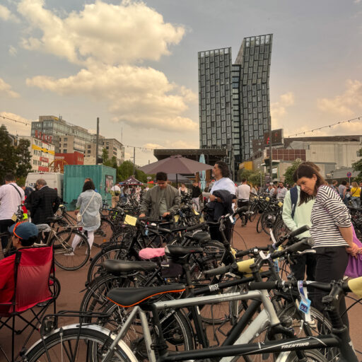Fahrräder auf einem großen Platz und viele Menschen