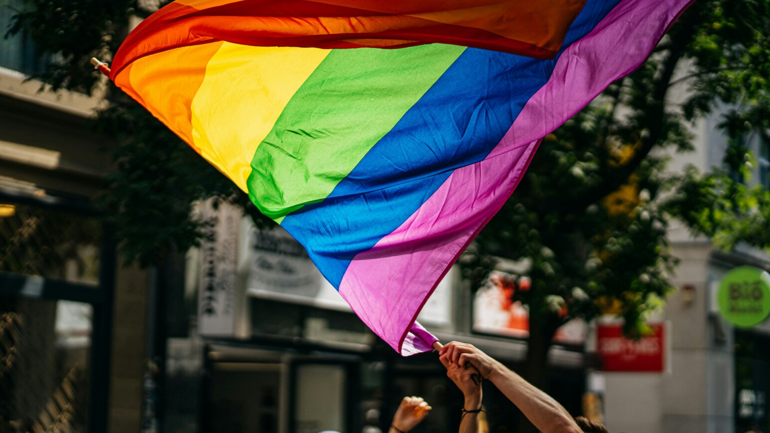 Eine Person schwingt die Pride-Flagge