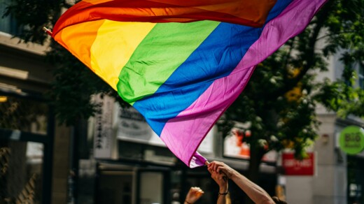 Eine Person schwingt die Pride-Flagge