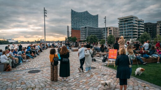 Menschen auf einem Platz an der Elbe vor der Elbphilharmonie