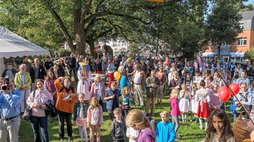 Eine Menschenmenge auf einer Wiese mit Ständen