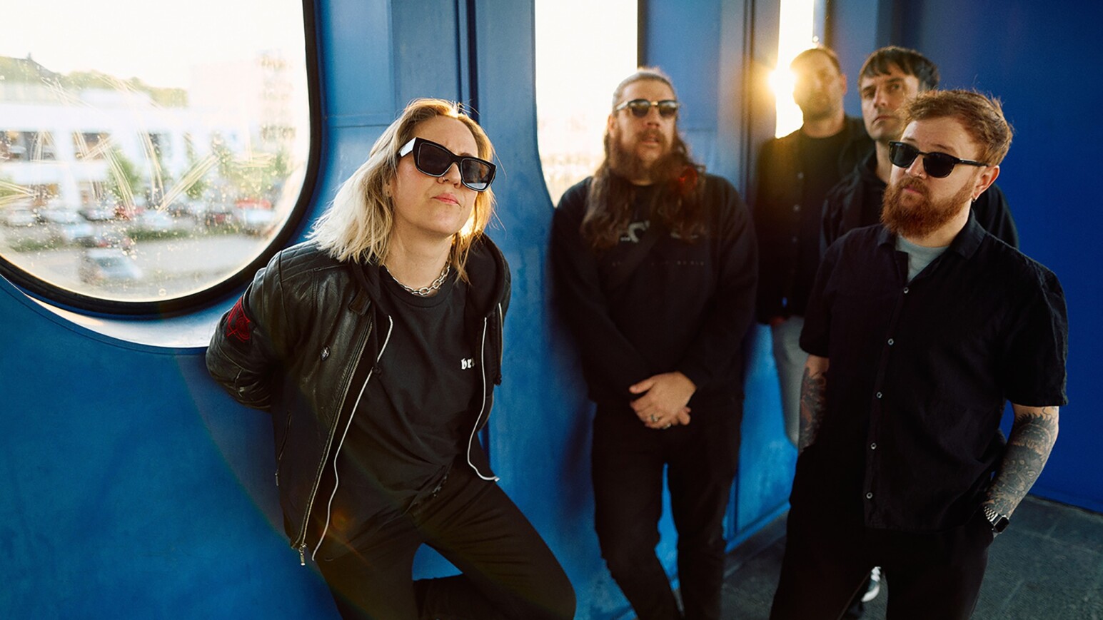 5 Personen vor einer blauen Wand mit Fenstern - Die Band Berlin 2.0