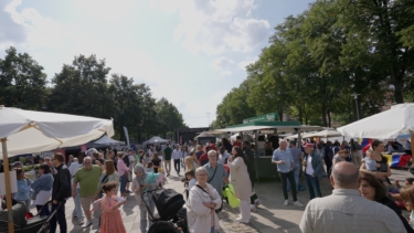 Viele Personen auf einem Platz mit Ständen