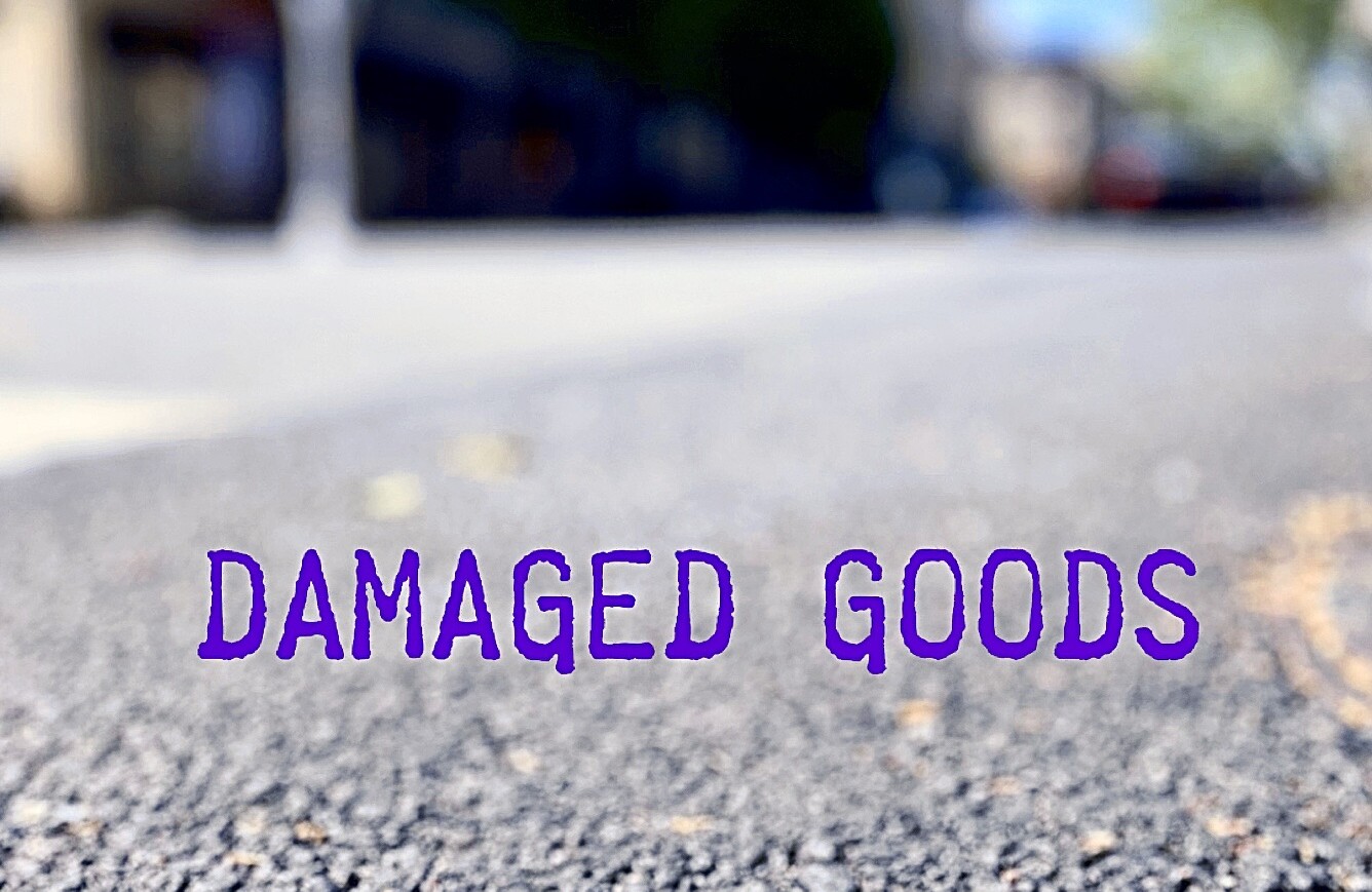 Straße im Close-Up - mit Schriftzug Damaged Goods