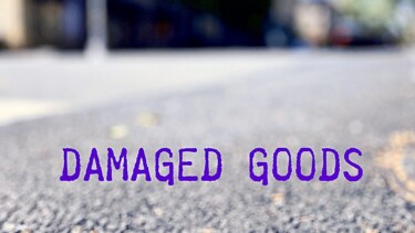Straße im Close-Up - mit Schriftzug Damaged Goods