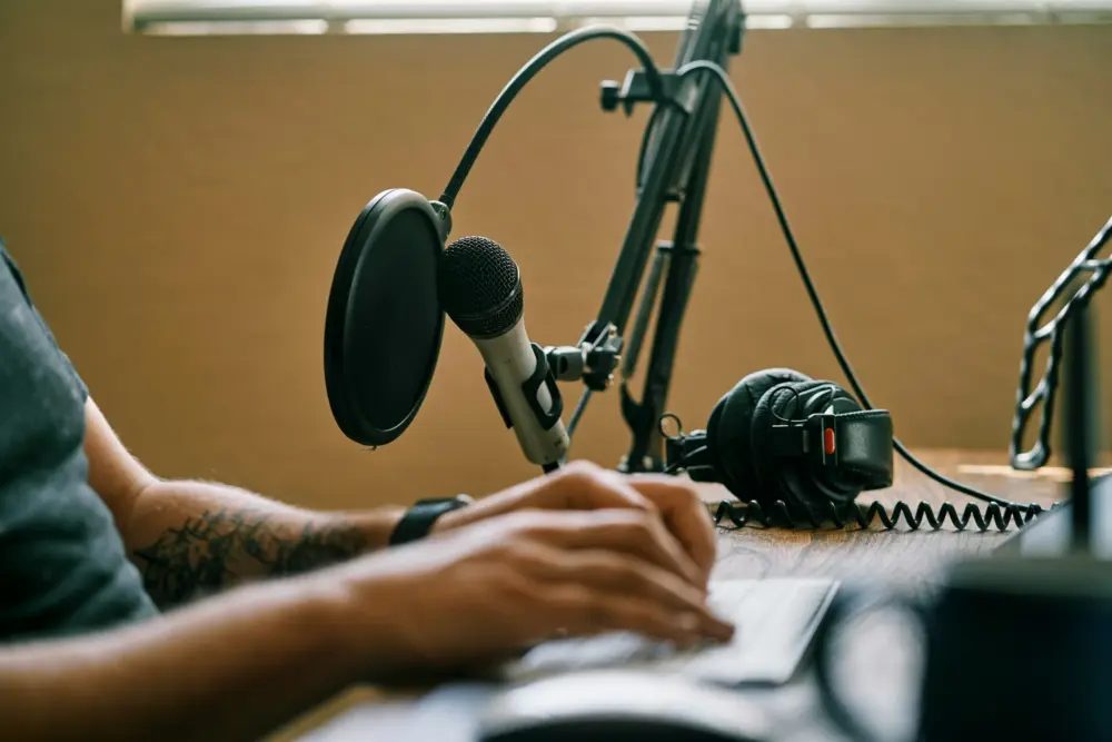 Person sitzt an einem Podcastmikro