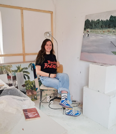 Laura Gómez im Studio, umgeben von ihrer Gemäldeserie, die auf Fotografien ihrer eigenen Familie basiert
