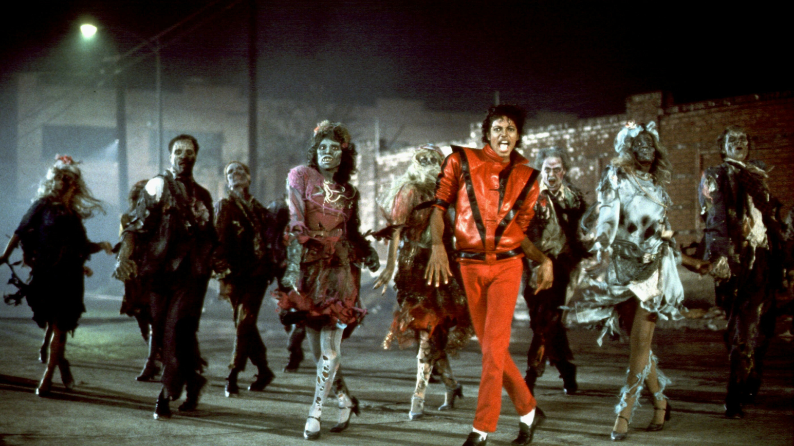 Bildausschnitt Musikvideo Thriller mit Michael Jackson im Vordergrund und Zombies um ihn herum