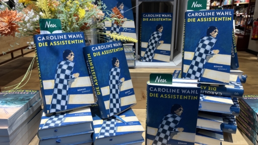 Diverse Romane "Die Assistentin" von Caroline Wahl zur Auslage in einem Buchladen.