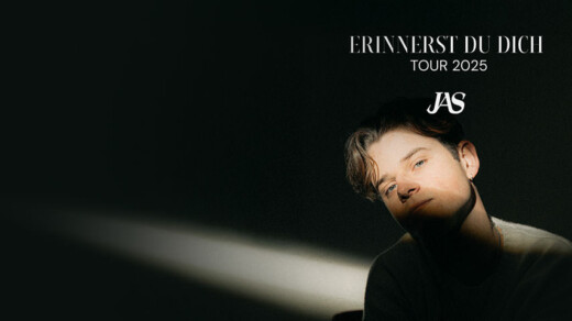 Mann mit dunklem Pullover sitzt im Lichtkegel vor schwarzem Hintergrund. Text darüber: 'ERINNERST DU DICH TOUR 2025 JAS'.