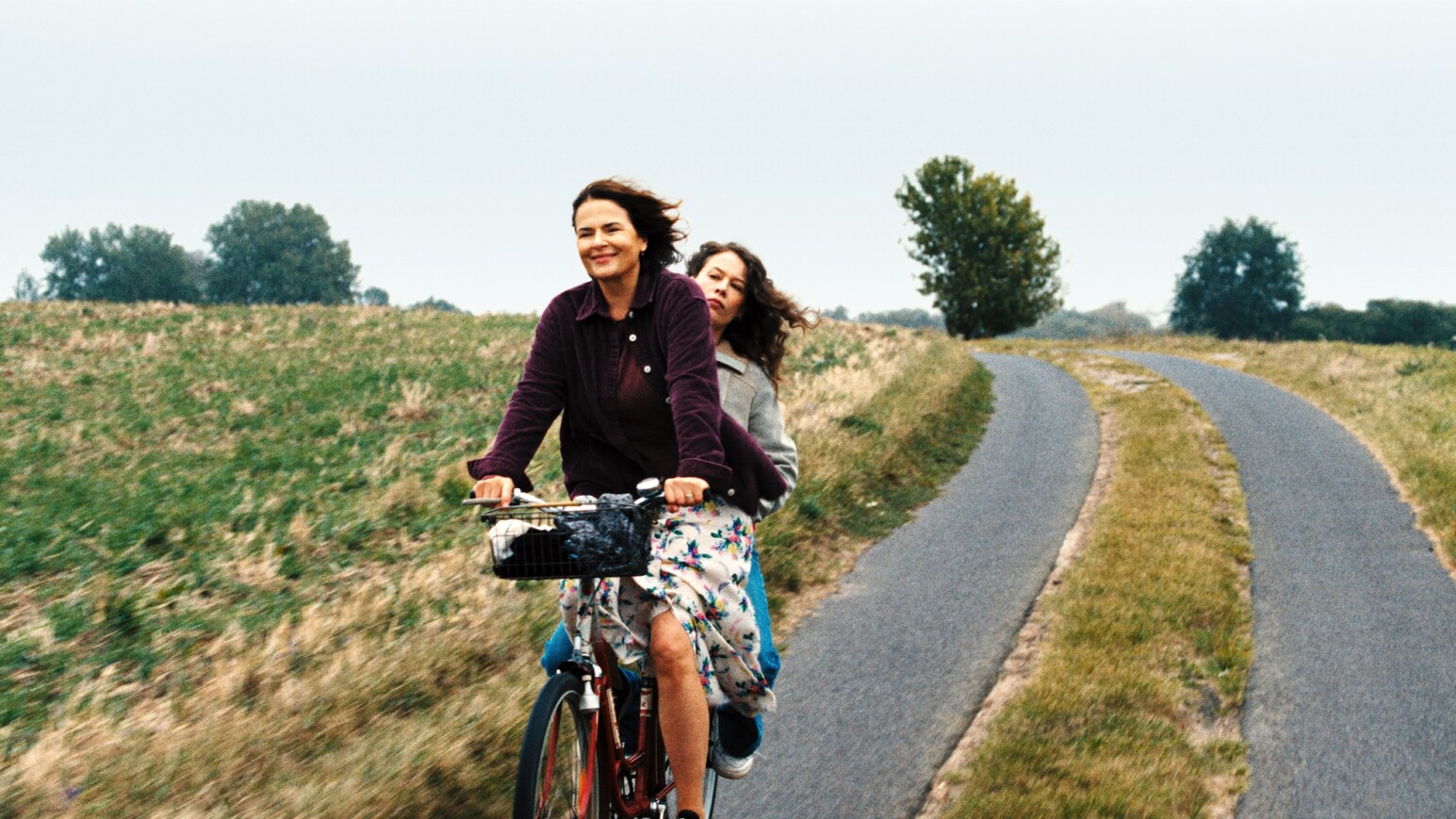 Zwei Frauen auf einem Fahrrad auf einem Feldweg