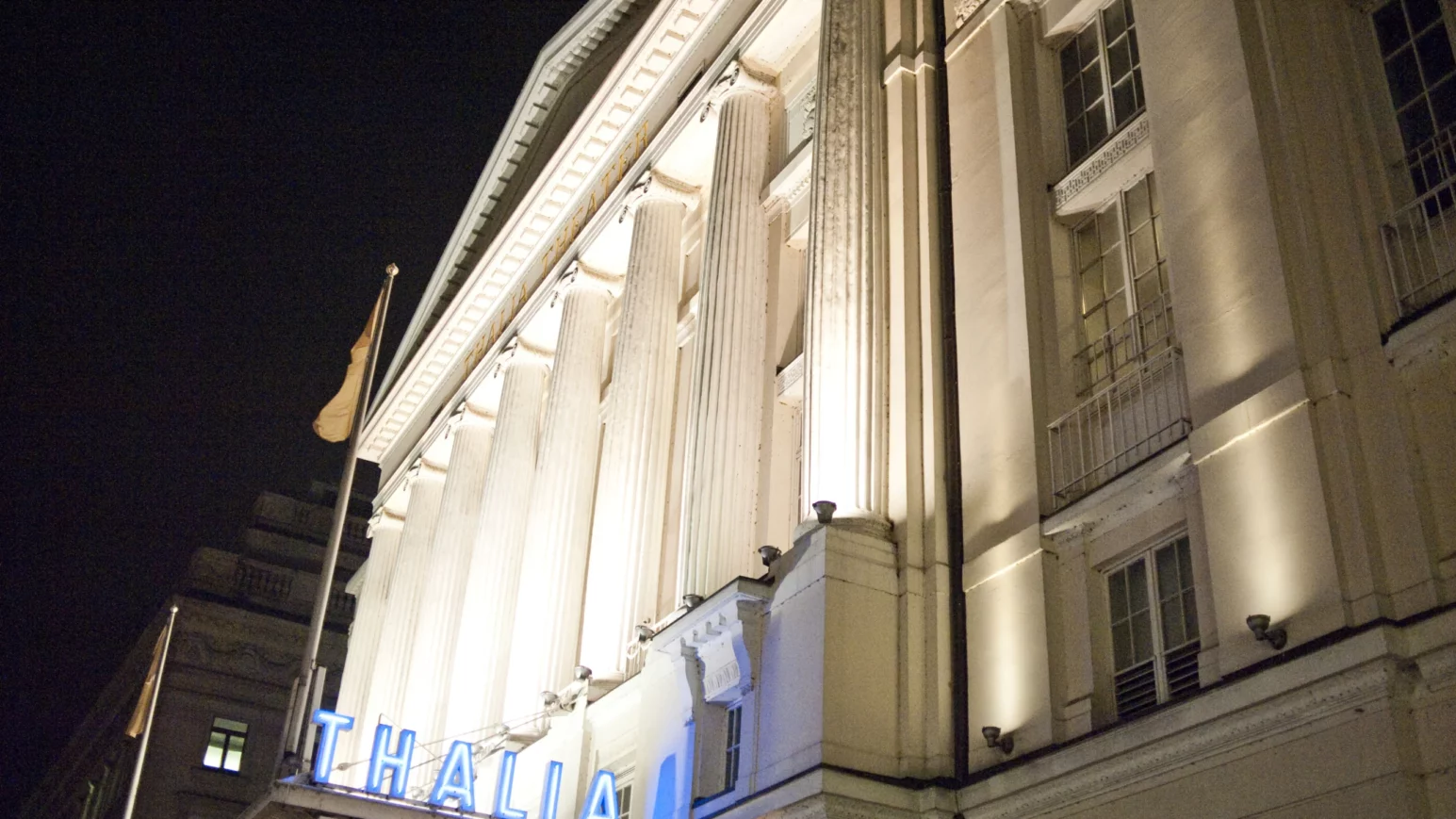 Großes Gebäude was von Lichtstrahlern angeleuchtet wird