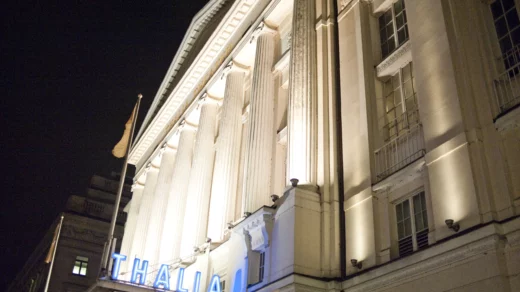 Großes Gebäude was von Lichtstrahlern angeleuchtet wird